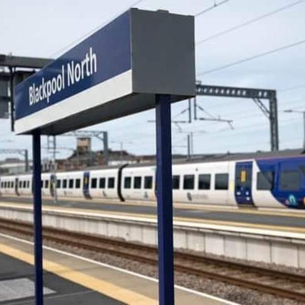 Blackpool North train station sign, with a train in the background